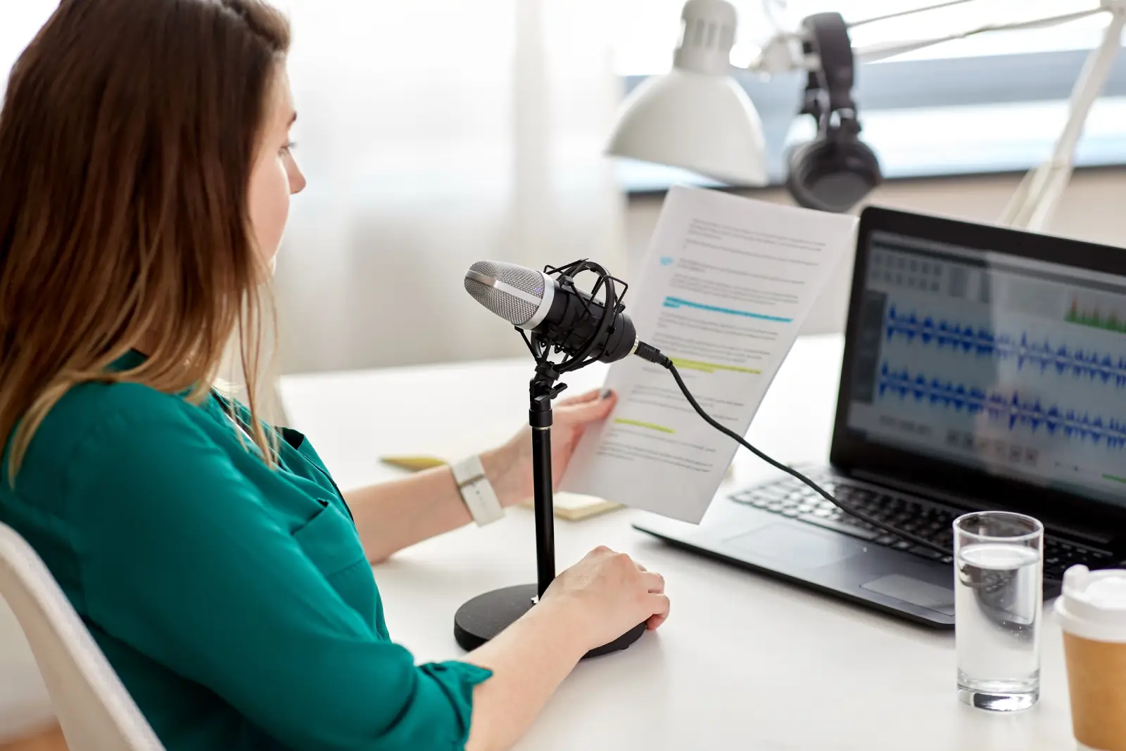 woman with microphone recording podcast at studio